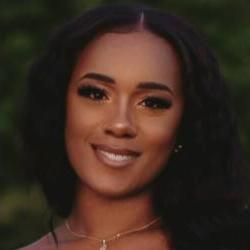 A headshot of an artist with long wavy hair